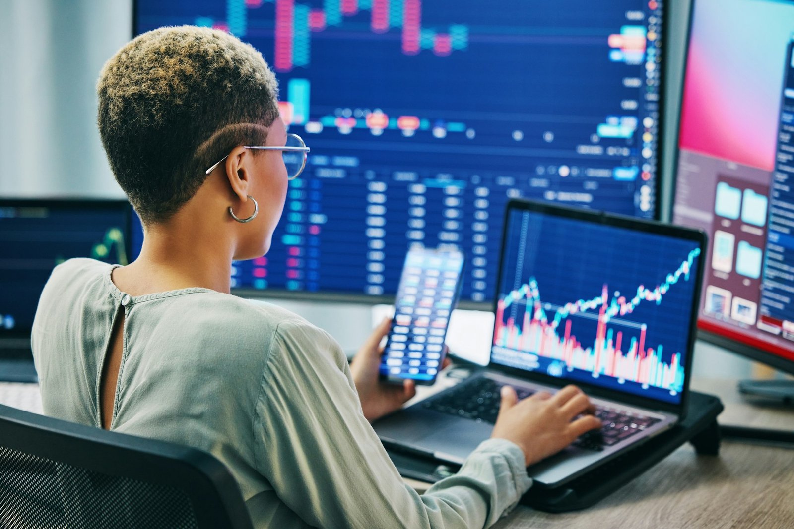 Femme d'affaires, téléphone et ordinateur portable sur le marché boursier en fintech, trading ou finance en ligne au bureau. F